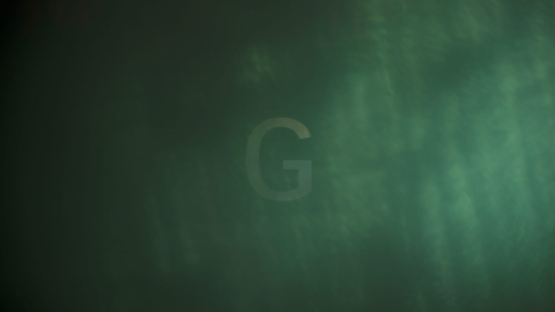 The Ghost G mark ghosting through a haze of green light.