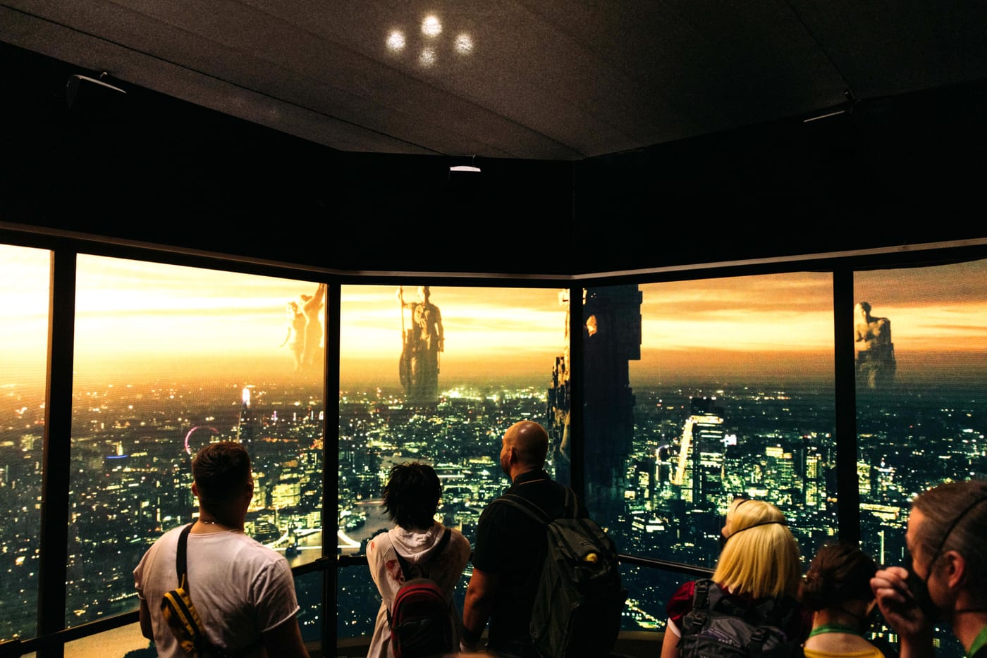Visitors at a skyline-view lounge activation at sunset, floor-to-ceiling windows over the city.
