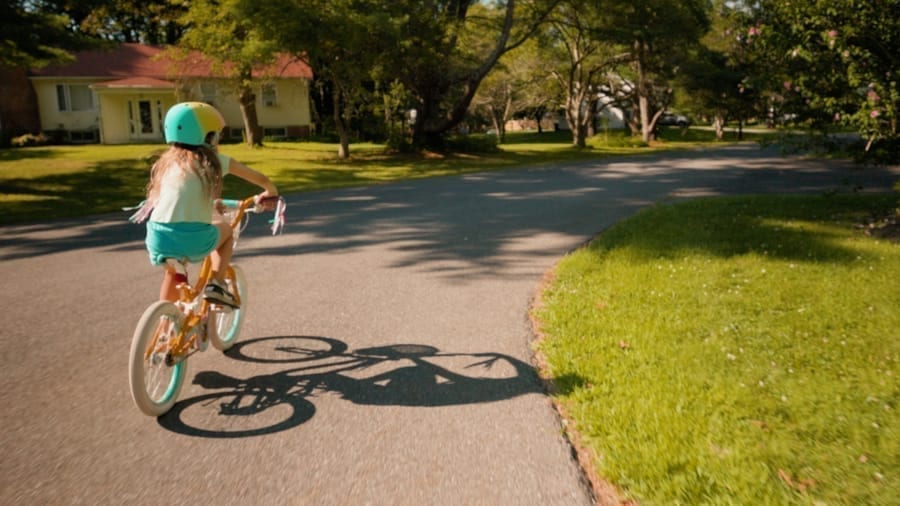 A child riding a bike down a suburban path, from the Outlaws music video.
