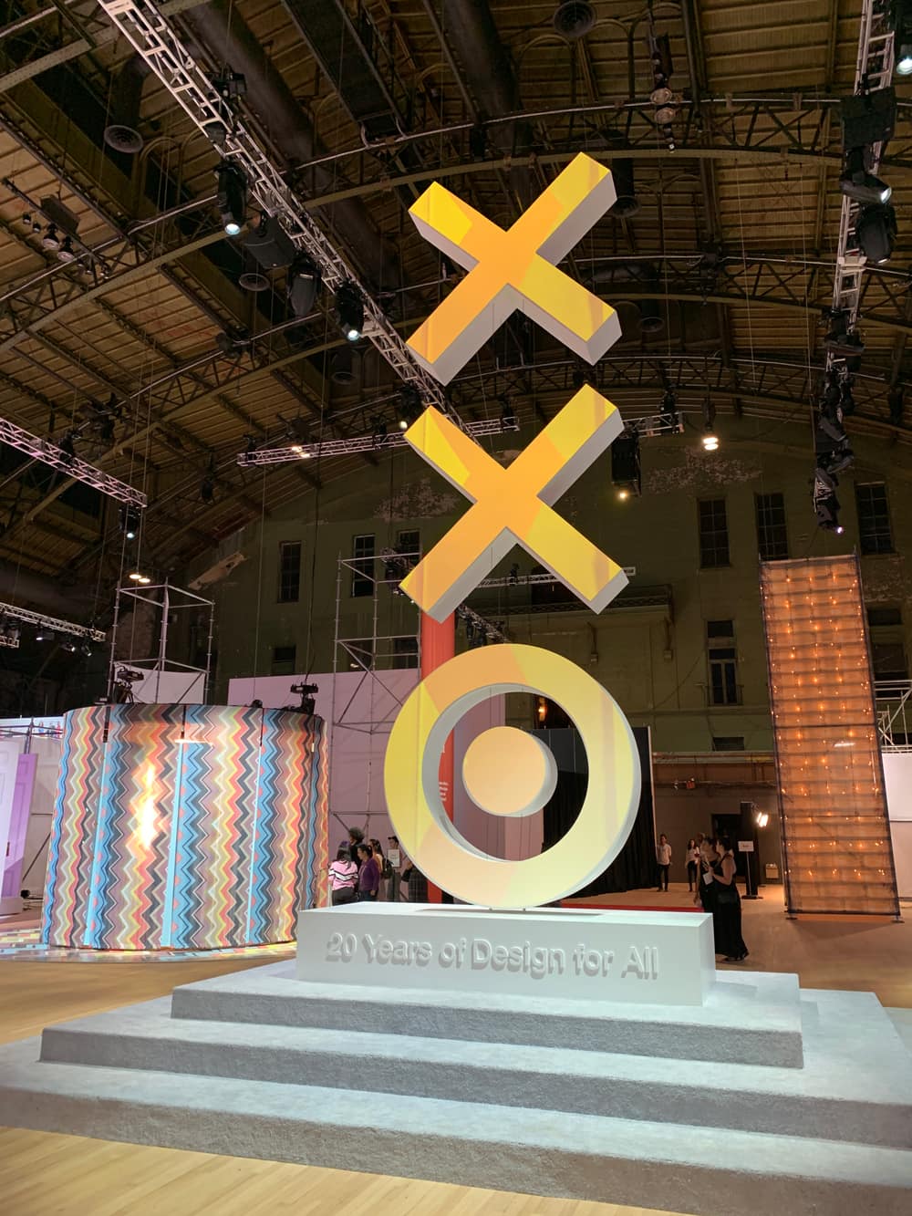 The Target 20 Years of Design for All installation — a tall stacked bullseye sculpture in yellow above a pedestal, in an armory hall.