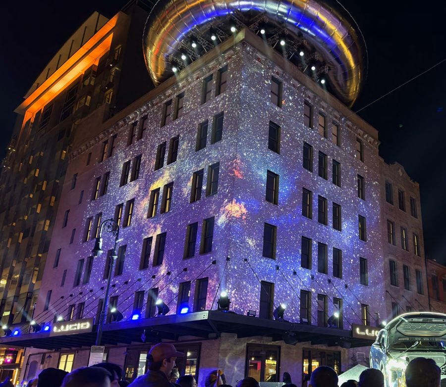 Lucid Gravity launch — cosmic projection wrapping a Meatpacking facade