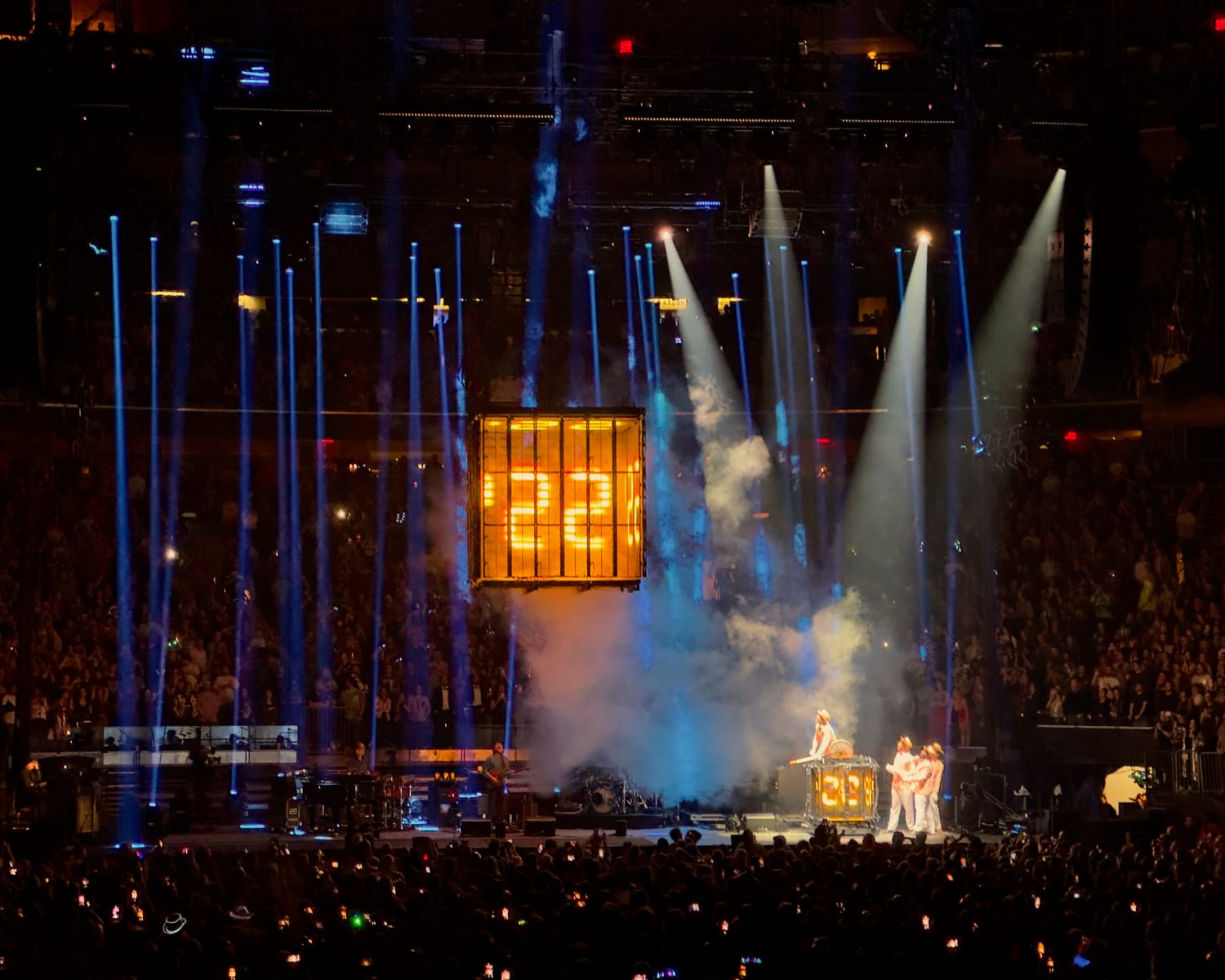 The glowing time-machine cube reading ’22’ suspended above the Madison Square Garden stage in blue light and smoke, the crowd filling the arena.