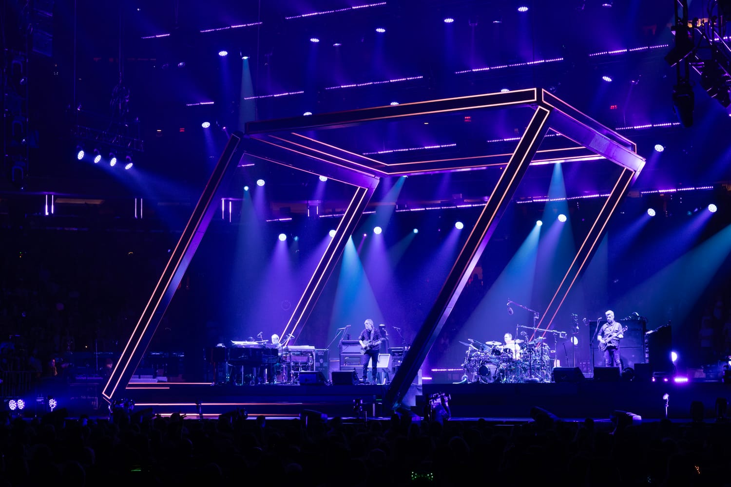 Phish at Madison Square Garden beneath the tilted angular LED frame, the stage bathed in violet and blue light.